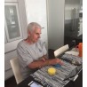 Mężczyzna z udarem mózgu, ćwiczy prawą rękę przy pomocy kompletu FitMi i tabletu.